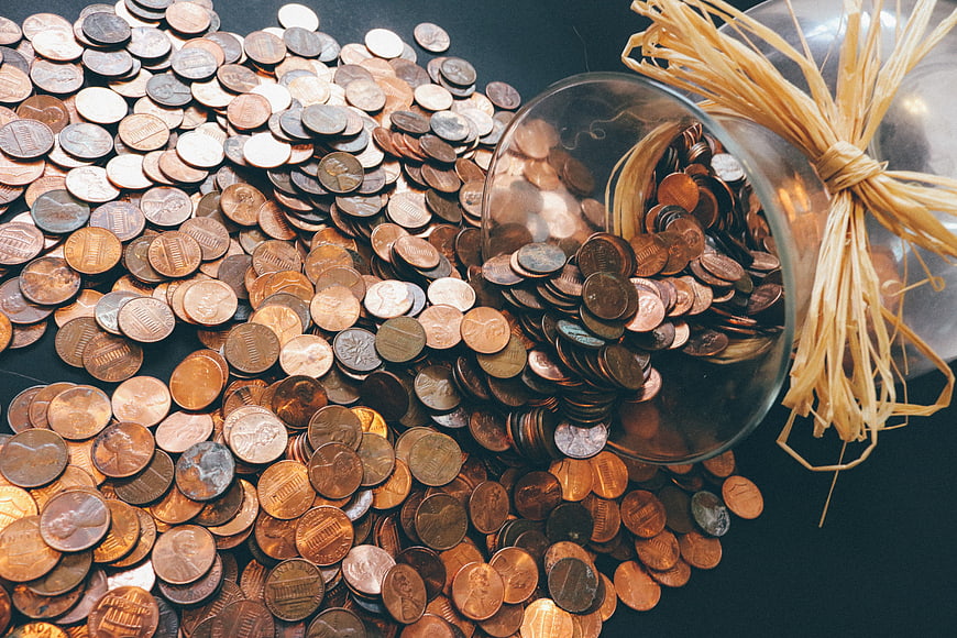 Pile of US Pennies Spilling from Glass Jar