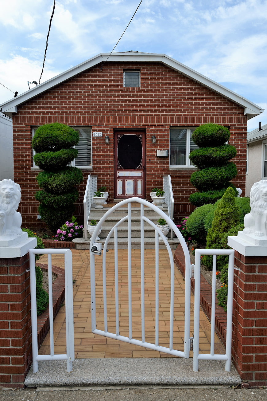 Red Brick House with White Gate and Lion Statues