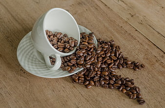 Spilled Coffee Beans in White Cup on Wooden Table