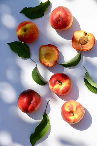 Fresh Peaches and Leaves on White Background
