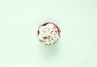 Top-Down View of Single Frosted Cupcake with Sprinkles on Mint Background