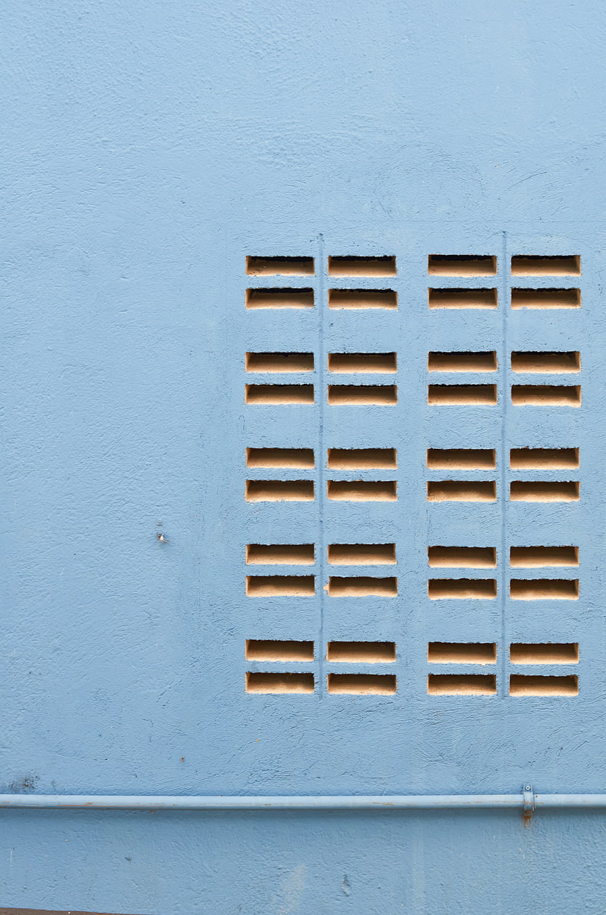 Blue Textured Wall with Geometric Ventilation Grille Pattern