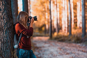 Female Photographer Taking Pictures in Autumn Forest