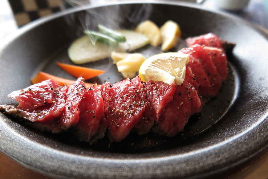 Sliced Rare Beef Steak With Lemon And Vegetables On Sizzling Plate