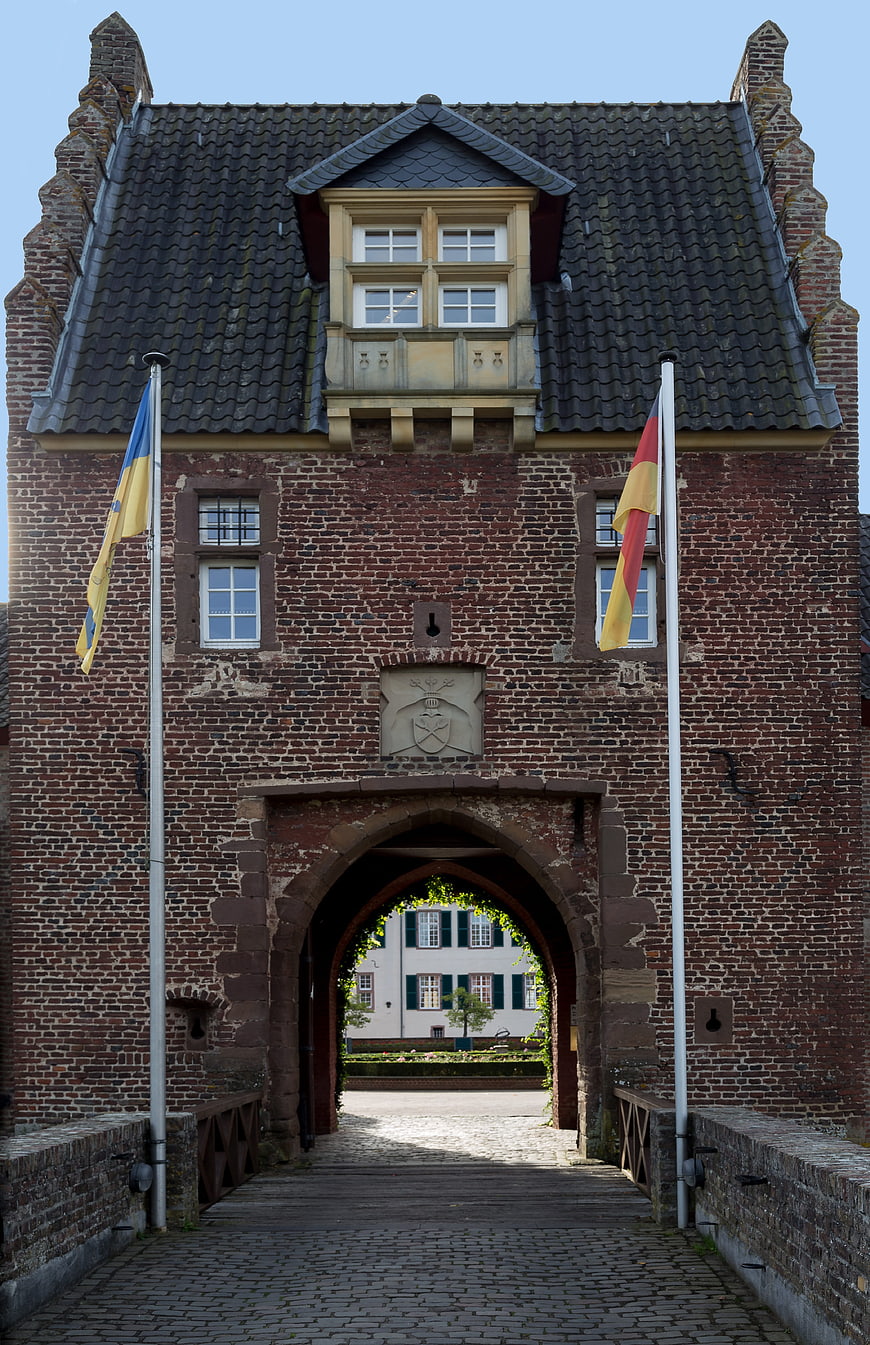Historic Brick Gatehouse with Flags and Cobblestone Bridge