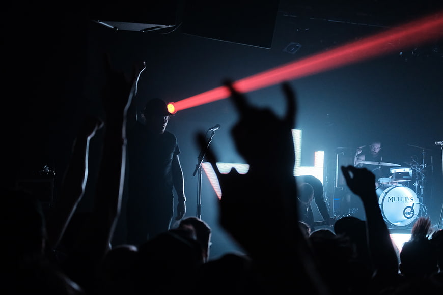 Silhouetted Rock Concert Crowd with Red Laser Light