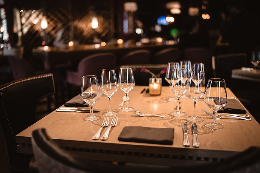 Elegant restaurant table setting with wine glasses and candlelight