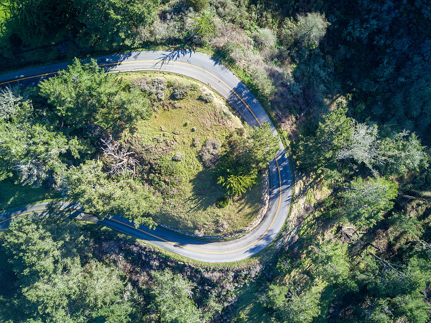 Aerial view of winding mountain road through forest