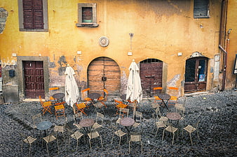 Empty outdoor cafe seating in historic European cobblestone square