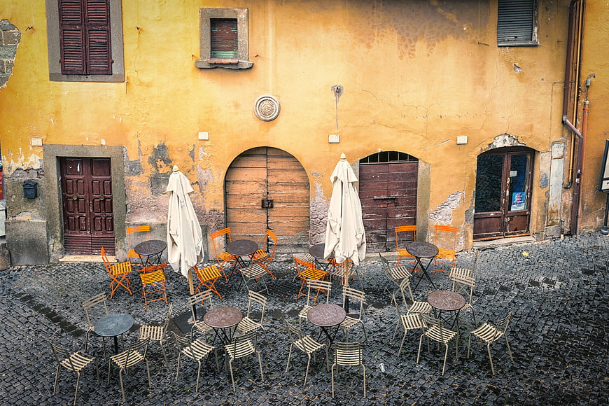 Empty outdoor cafe seating in historic European cobblestone square