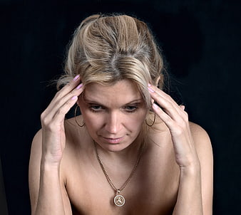 Portrait of a distressed woman holding her head in pain