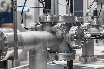 Close-up of industrial stainless steel pipes and flanges in a factory