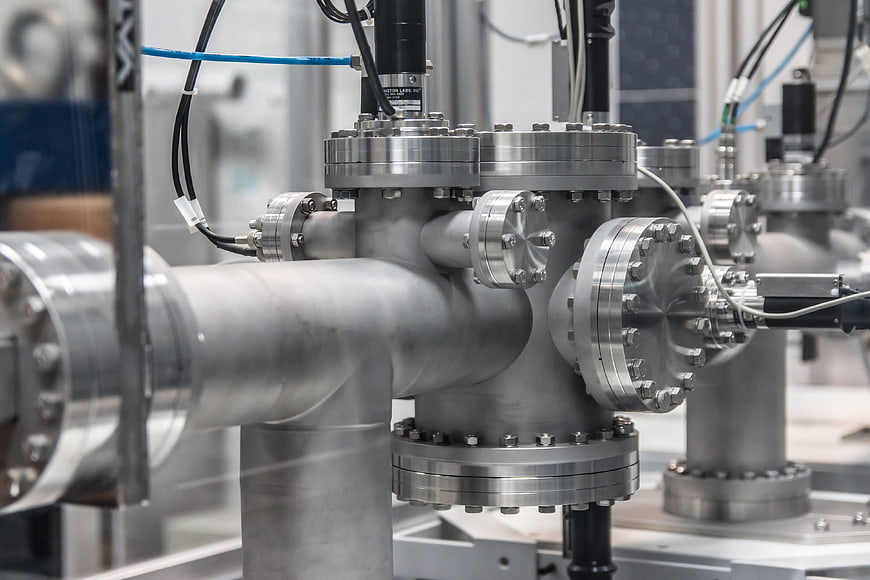 Close-up of industrial stainless steel pipes and flanges in a factory