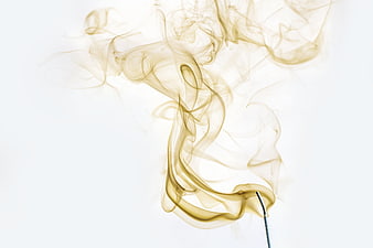 Golden incense smoke swirling on white background