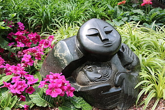 Black stone mother and child sculpture in garden