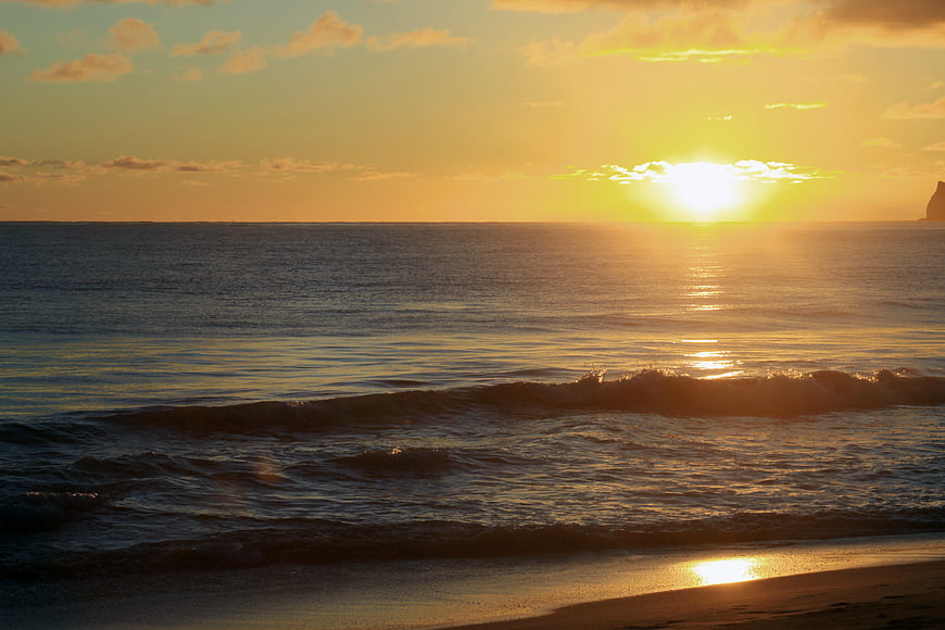 Golden Sunset Over Calm Ocean Waves on Sandy Beach