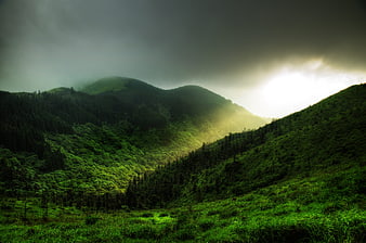 Dramatic Sunlight Breaking Through Clouds Over Green Mountain Valley