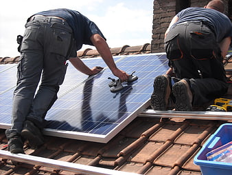 Workers Installing Solar Panels on Residential Clay Tile Roof