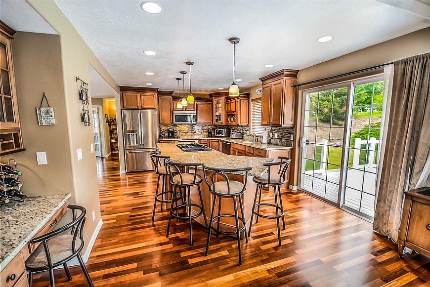 Spacious Kitchen with Island, Barstools, and Hardwood Floors