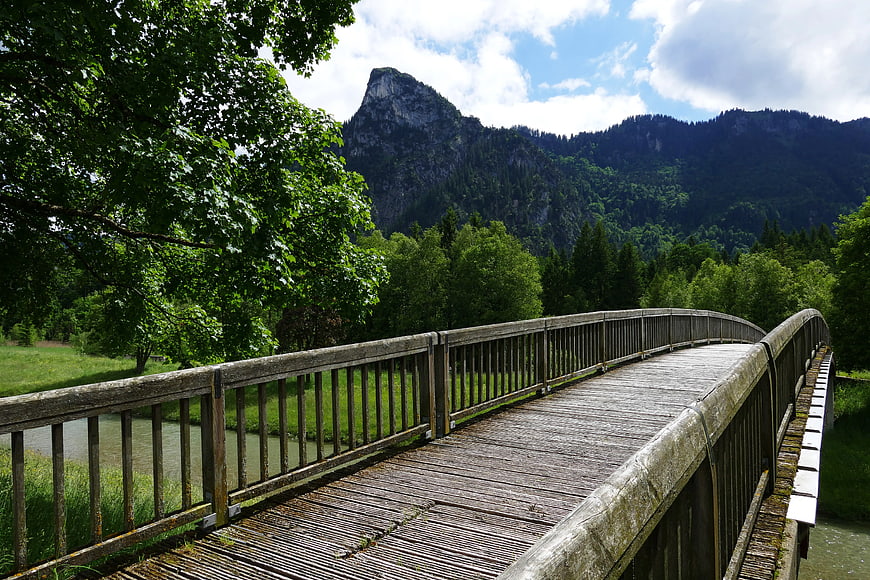 Wooden Bridge Over River with Mountain Background