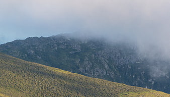 Misty Mountain Ridge with Sunlit Forest Slope