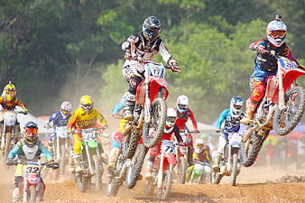 Motocross Riders Jumping on Dirt Track