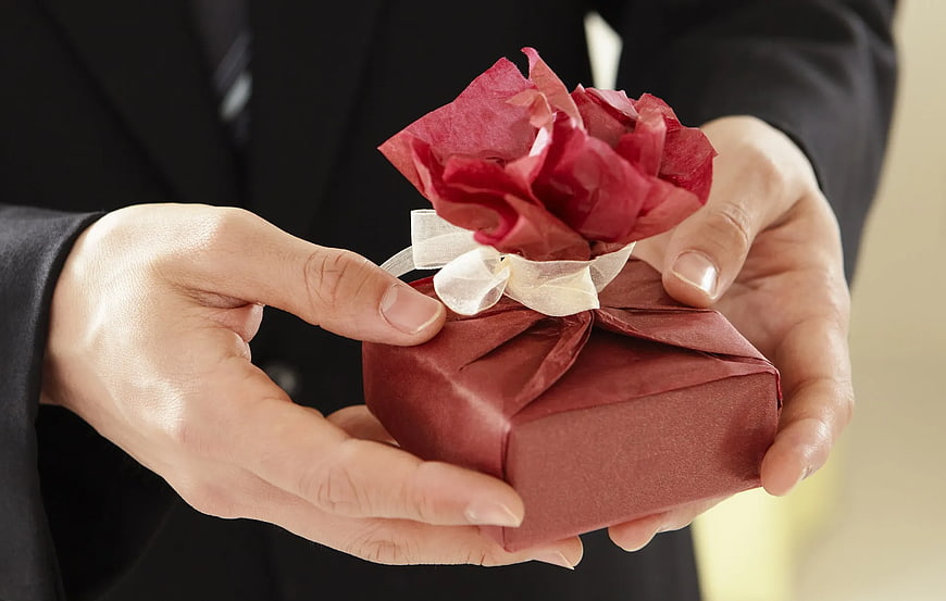 Man in Suit Holding Red Gift Box with Rose