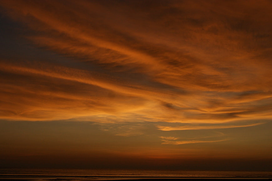 Dramatic Orange Sunset Sky Over Ocean Horizon