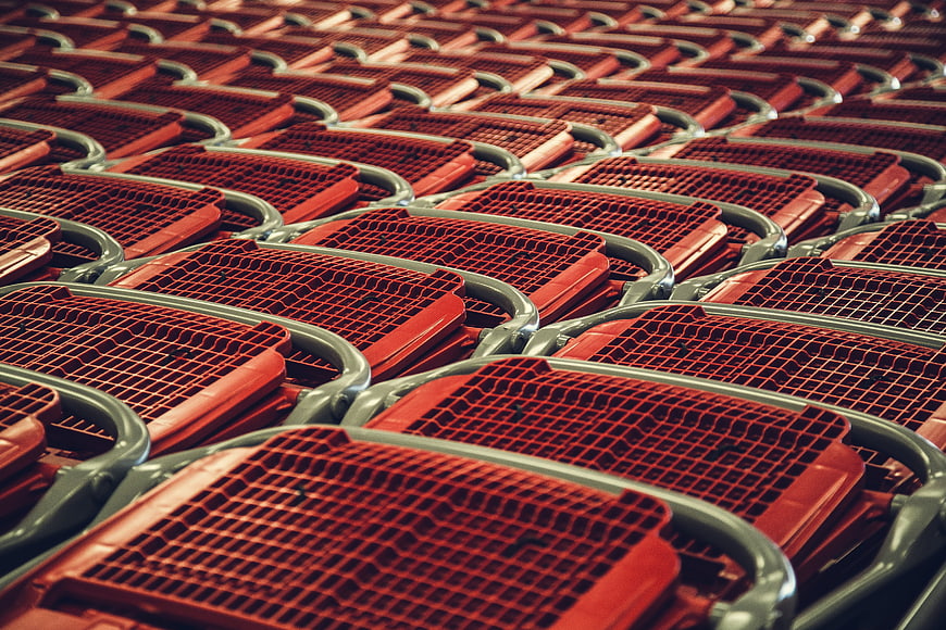 Rows of red stadium seats with metal frames
