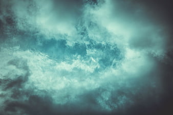 Dramatic teal and grey storm clouds swirling in the sky