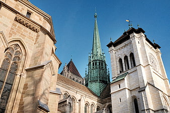 Gothic Cathedral Architecture with Green Spire and Stone Towers