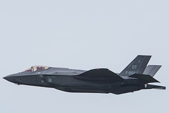F-35 Lightning II fighter jet in flight against gray sky