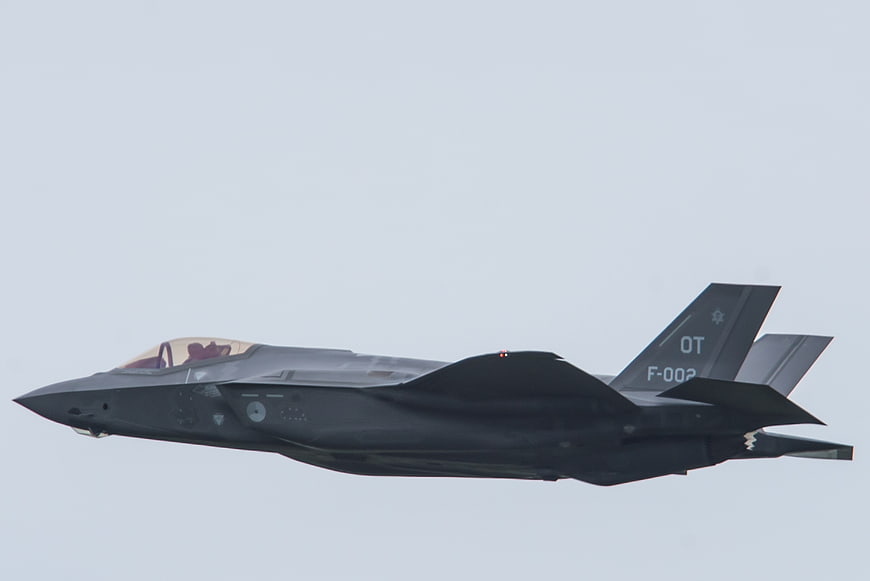 F-35 Lightning II fighter jet in flight against gray sky