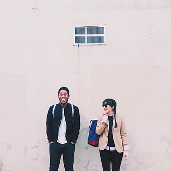 Happy Diverse Couple Laughing Against Textured Wall