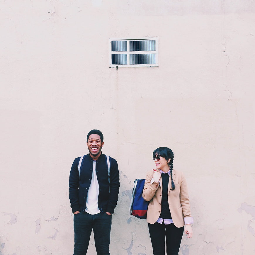 Happy Diverse Couple Laughing Against Textured Wall
