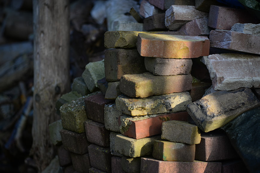 Stack of weathered bricks with sunlight and shadows