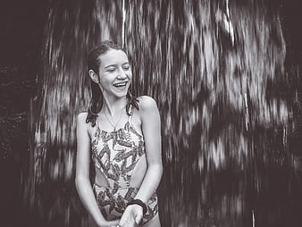 Laughing Girl in Swimsuit Under Waterfall
