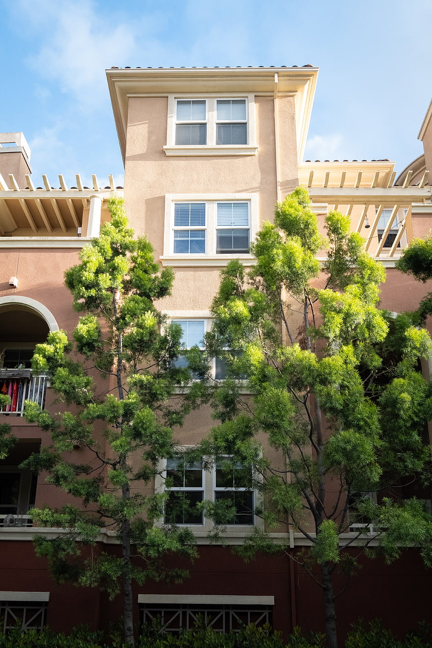 Multi-story apartment building exterior with green trees
