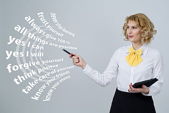 Businesswoman writing motivational phrases on transparent screen