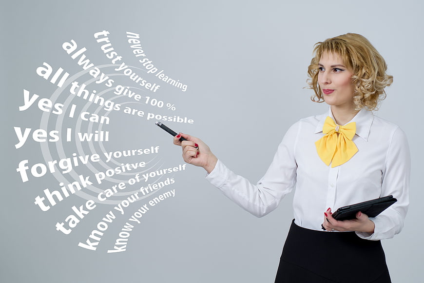 Businesswoman writing motivational phrases on transparent screen