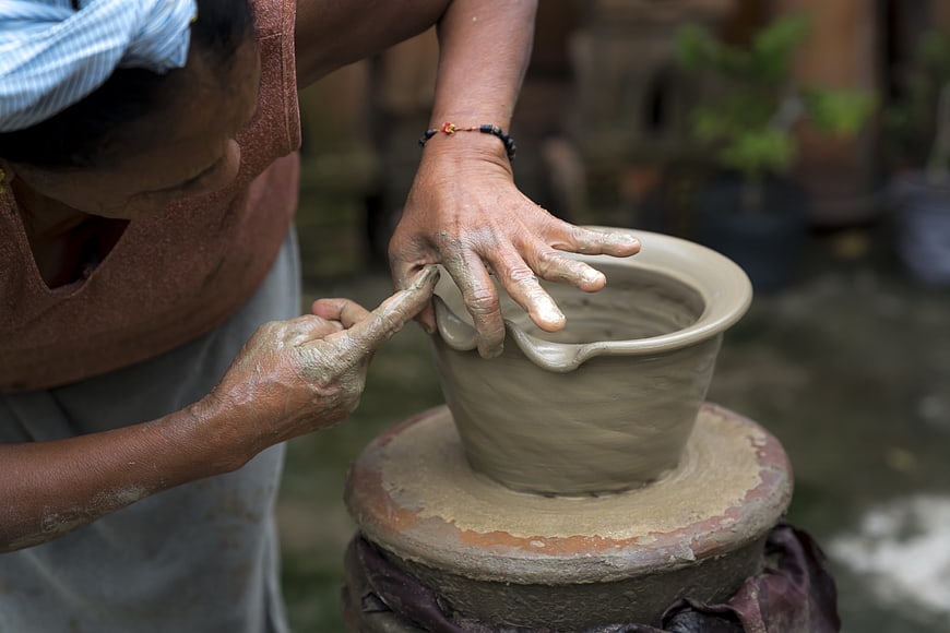 Close-up of artisan hands shaping clay on a traditional pottery wheel