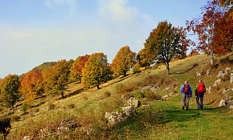 Two Hikers Walking on Autumn Mountain Trail in Lessinia Italy