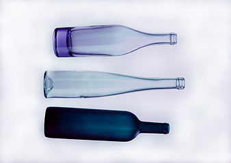 Three Glass Bottles in Blue and Purple Tones on White Background