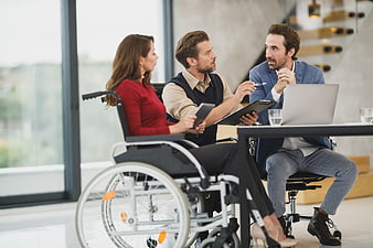 Business meeting with woman in wheelchair discussing strategy