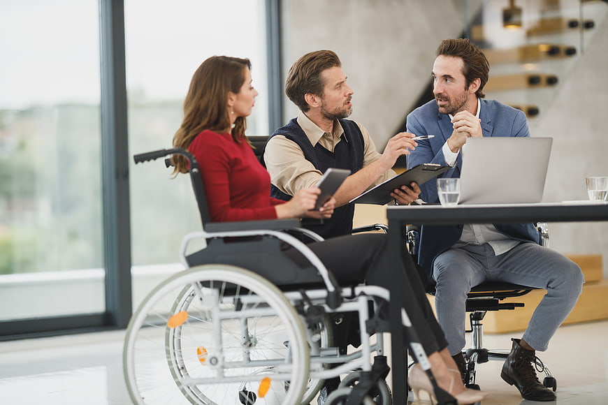 Business meeting with woman in wheelchair discussing strategy