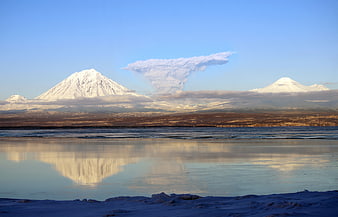 Snowy Mountain Peaks Reflected in Frozen Lake with Cloud