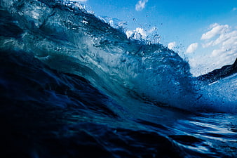 Dynamic Blue Ocean Wave Crashing with Sky Background
