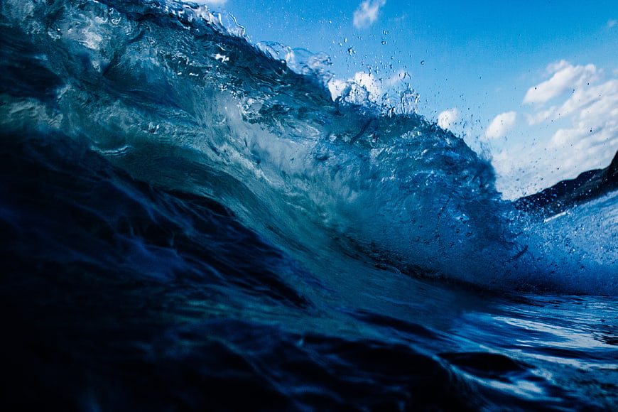 Dynamic Blue Ocean Wave Crashing with Sky Background