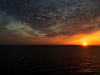 Dramatic Sunset Over Ocean with Textured Clouds