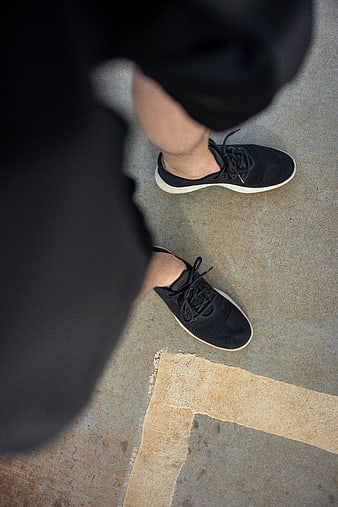 High angle view of black sneakers on concrete pavement
